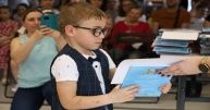 Chłopczyk w okularach odbiera nagrodę i dyplom.