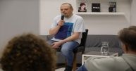 Leszek Gnoiński na krześle z mikrofonem.
