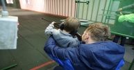 Mężczyzna z dzieckiem strzelają na strzelnicy do celu.
